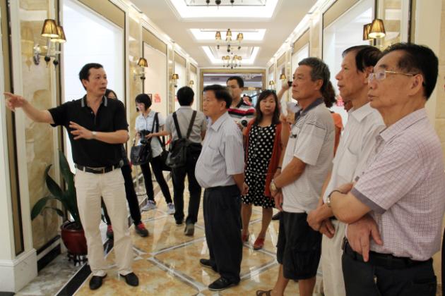 图3、尊龙凯时人生就是搏市场总监霍达炎（左一）在为旅行者先容釉面砖展示空间.jpg